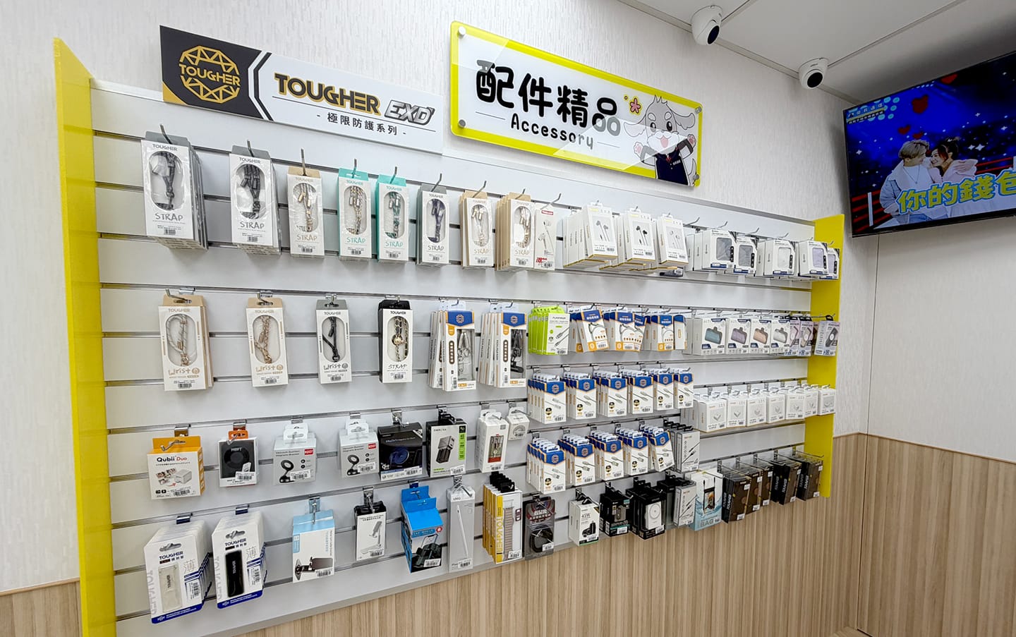 傑昇通信門市「配件精品」陳列牆,展示 TOUGHER 極限防護系列、手機掛繩、充電線、充電頭及 3C 周邊配件。