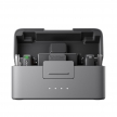 DJI Mic Mini 無線麥克風充電盒，灰色盒身開蓋展示，內含接收器與發射器，前方四顆電量指示燈，標示穩定傳輸、主動降噪與輕量設計圖示